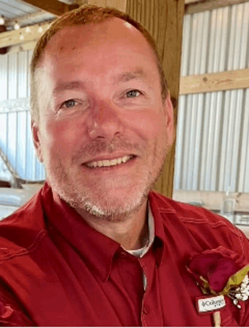 a man wearing a red shirt with a name tag that says ' columbia ' on it