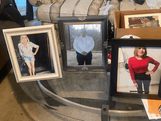 several framed pictures on a glass table including one of a man and a woman