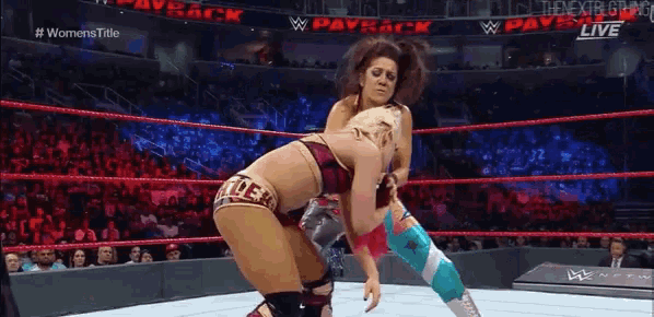 two women are wrestling in a ring with the words #womens title on the bottom