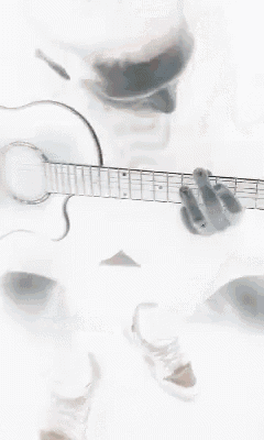 a close up of a cat playing a guitar on a white surface .