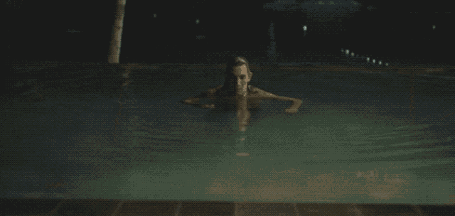 a woman is swimming in a pool with her head above the water