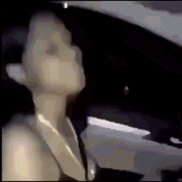 a woman is sitting in the driver 's seat of a car with her eyes closed .