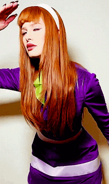 a woman with long red hair is wearing a purple dress