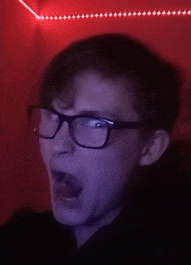 a man wearing glasses is making a funny face with his mouth open .