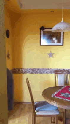 a dining room with a table and chairs and a picture on the wall above the table