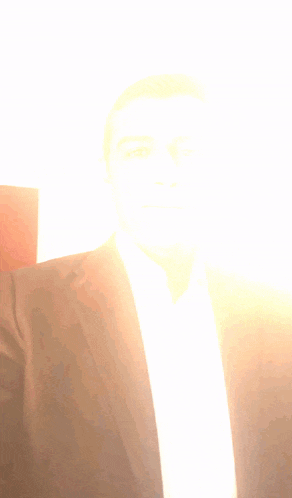 a man in a suit and white shirt is taking a picture of himself