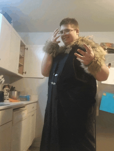 a man in a fur coat stands in front of a refrigerator