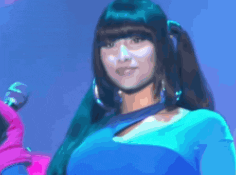 a woman in a blue dress is holding a microphone and looking at the camera .