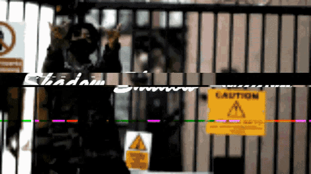 a blurry picture of a fence with a caution sign on it