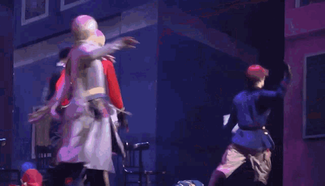 a group of people are dancing on a stage and one of them is holding a piece of paper
