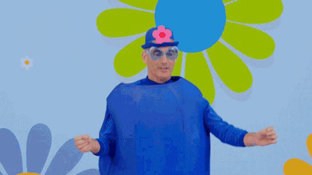 a man wearing a blue costume with a flower on his hat