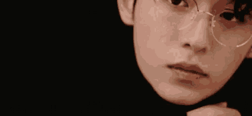 a close up of a person wearing glasses and a black shirt