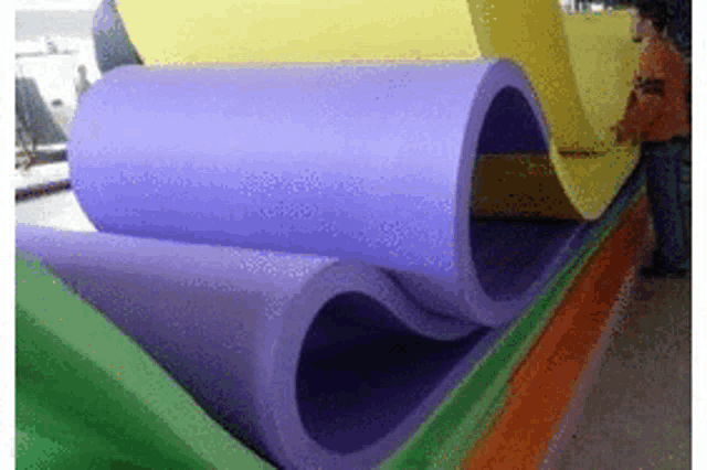 a bunch of different colored foam rolls are stacked on top of each other on a table