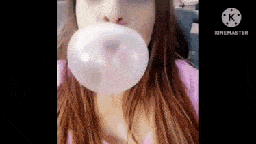 a woman is blowing a bubble with a gum .
