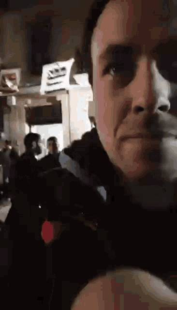 a man is taking a picture of himself in front of a crowd of people