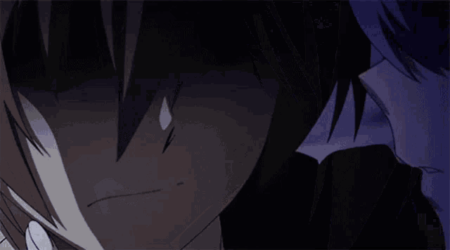 a close up of a girl licking a boy 's face in a dark room
