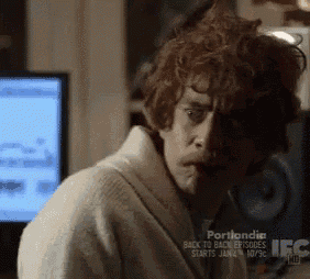 a man in a white robe is sitting in front of a computer screen that says portlandia ifc
