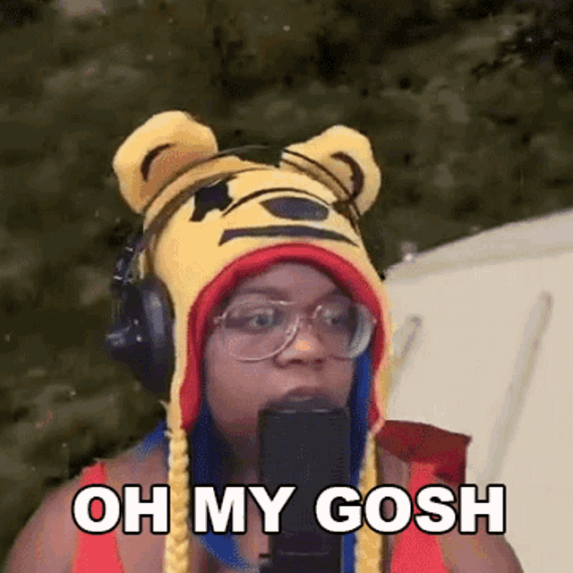 a woman wearing a winnie the pooh hat and headphones is speaking into a microphone .