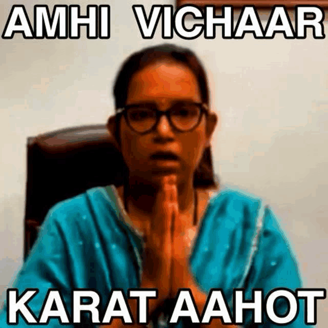 a woman is sitting in a chair with her hands folded in prayer .