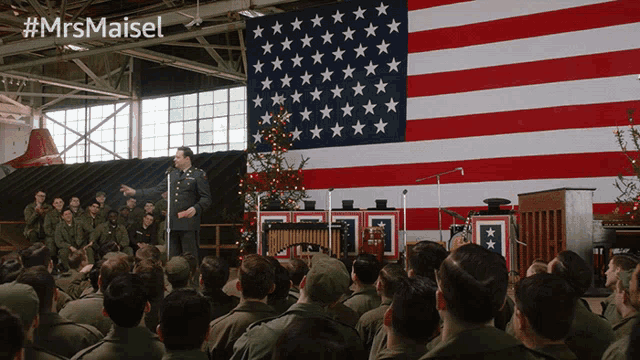 a group of soldiers sitting in front of an american flag