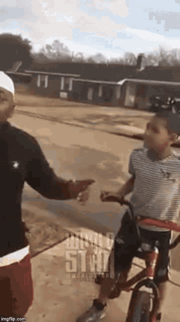 a man and a child are standing next to each other on a sidewalk .