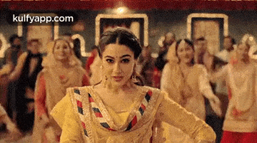 a woman is dancing in front of a crowd of people .