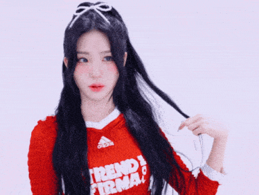 a girl wearing a red shirt that says trend firma on it