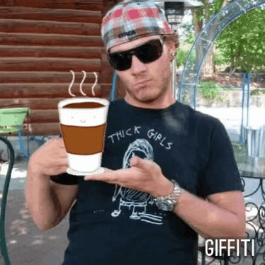 a man wearing a shirt that says thick girls holds a cup of coffee