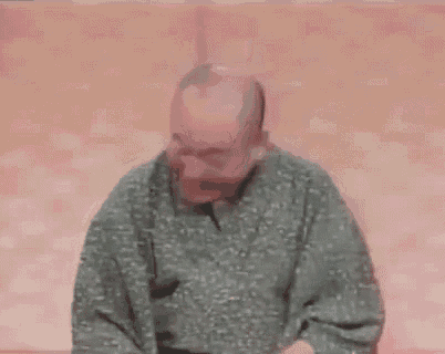 a bald man is covering his face with his hands while wearing a kimono .