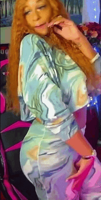 a woman with long red hair is wearing a blue and white top