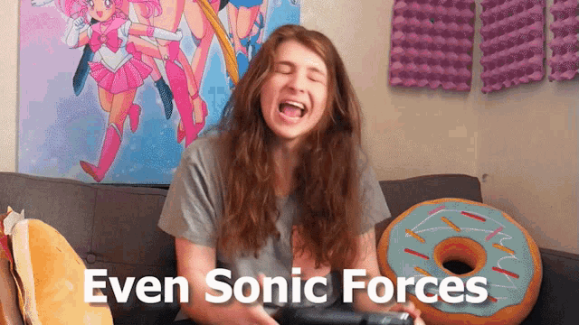 a woman is sitting on a couch with a donut pillow and a poster that says even sonic forces