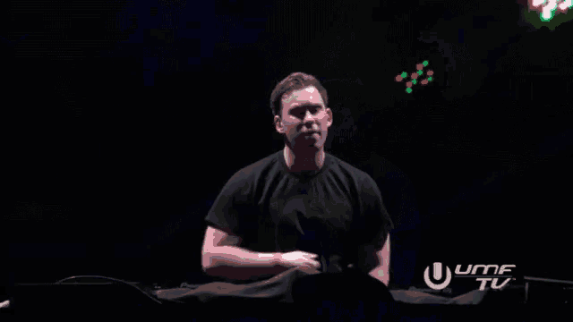 a man in a black shirt is standing in front of a sign that says uhf tv