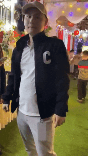 a man wearing a black jacket with a letter c on it