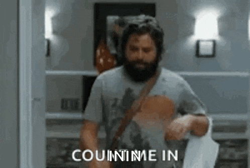 a man with a beard is holding a piece of paper and saying `` count me in '' while standing in a room .