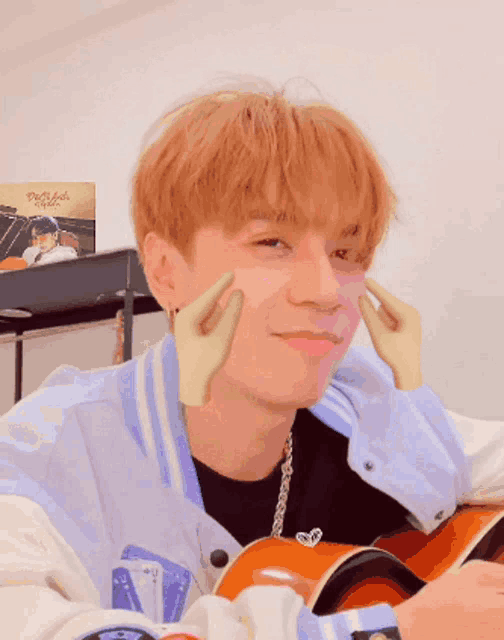 a young man with red hair is making a funny face with his hands on his cheeks