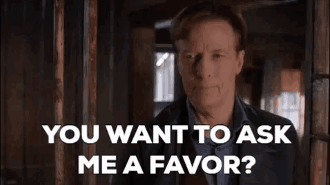 a man in a suit is standing in a hallway and asking if he wants to ask me a favor .