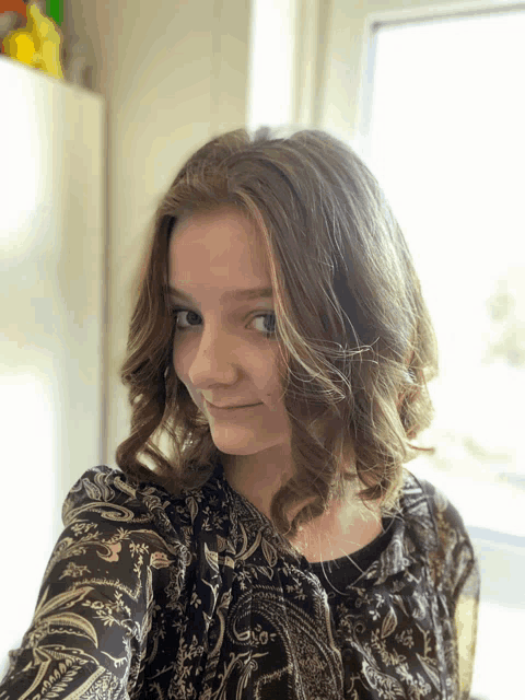 a girl taking a selfie wearing a black paisley shirt