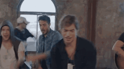 a group of young men are dancing in a room with a statue in the background .