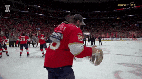 a hockey player holding a trophy with the number 28 on his jersey