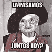 an elderly woman wearing a hat and glasses is making a funny face while sitting in a chair .