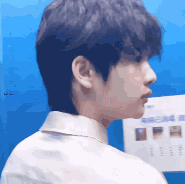 a close up of a person 's face with a blue background and the word hotchae on the bottom right