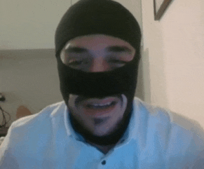 a man wearing a black mask and a white shirt smiles