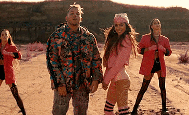 a man and two women are holding hands in the desert