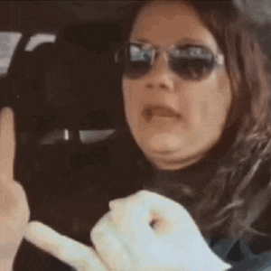 a woman wearing sunglasses is making a funny face while sitting in a car .
