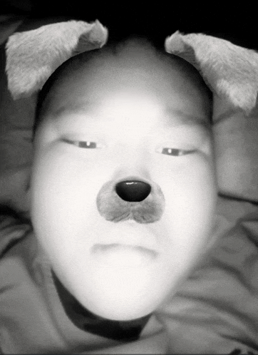 a black and white photo of a person with dog ears on their head