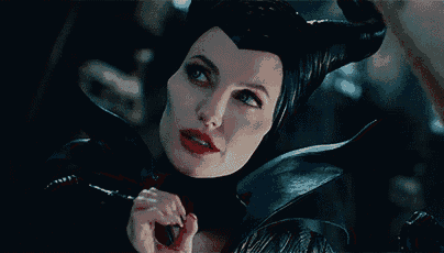 a woman with horns on her head is holding her finger to her lips .