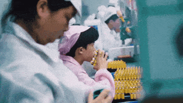 a woman wearing a pink head scarf is working in a lab