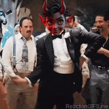 a man in a tuxedo with devil horns on his face