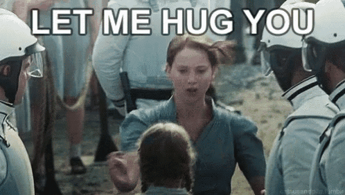 a woman is hugging a child in front of a crowd of people .