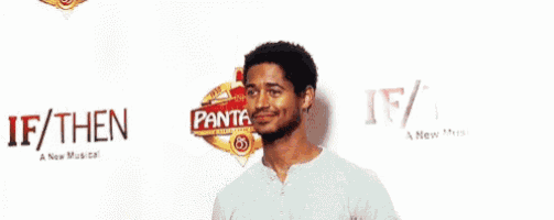 a man with a beard is standing in front of a sign that says ' pantag ' on it .